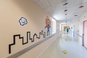 Uno de los pasillos del hospital decorado con un mural